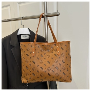 Detail of caramel tote bag showing bear patterns and reinforced gold metal rivets