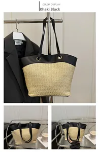 Detail of khaki straw tote bag with black leather handles and golden metal eyelets