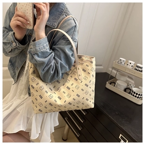Beige tote bag with cartoon bear pattern shown on model for a stylish casual look