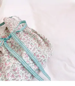 Detail of floral fabric backpack with pink flower pattern and blue checkered straps