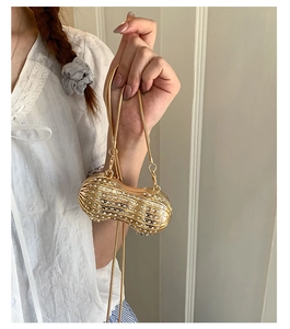 Vue détaillée d'un sac de soirée doré en forme de cacahuète orné de strass étincelants