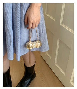 Détail du mini sac chaîne en forme de cacahuète avec finition métallique or et argent