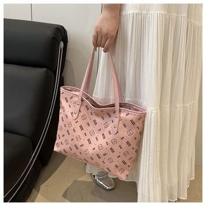 Detail of pink tote bag with cartoon bear pattern and reinforced metal rivets on handle