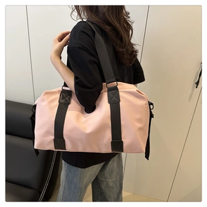 Sac de voyage rose avec sangles noires porté par un mannequin pour voir la taille