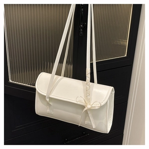 Detalle de bolso de hombro rectangular blanco con lazo decorativo sobre piel sintética brillante