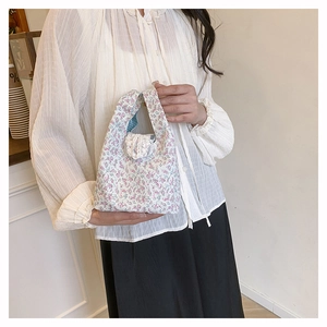 Detail of floral tote bag featuring white lace trim and delicate pink flower patterns