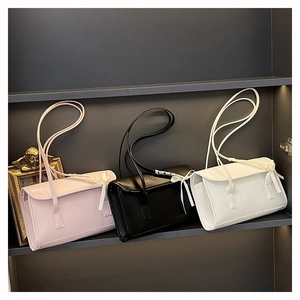 Detalle de bolsos baguette en rosa negro y blanco con delicados lazos laterales