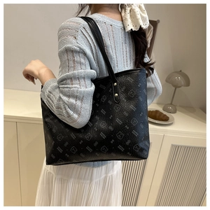 Detailed view of black tote bag featuring litchi texture and cute bear pattern print