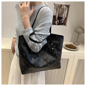 Detail of black tote bag with cute bear print and textured synthetic leather surface