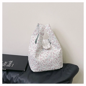 Detailed close-up of floral tote bag with pleated handles and textured cotton fabric
