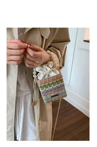 Détail du sac seau tissé à la main avec poignée en perles et motifs à vagues colorés