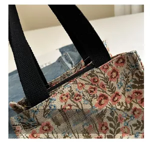 Detail of vintage jacquard floral canvas bag with sturdy black strap and zipper closure
