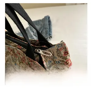 Close-up of a smooth silver zipper and floral canvas fabric on a casual tote bag