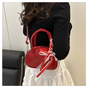 Red patent leather Boston bag with embossed heart and decorative lace ribbon bow