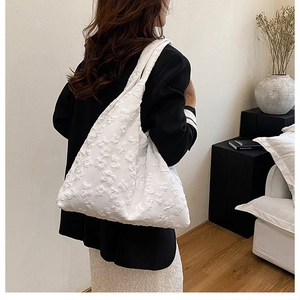 Detail view of 3D floral lace embroidery on a white canvas tote bag for women