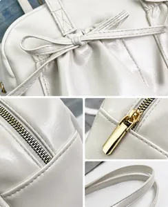 Detail van de crème tote bag van imitatieleer met strikplooien en gouden ritsdetails