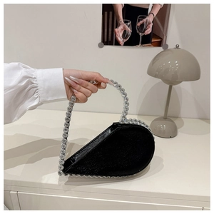 Detalle de bolso de fiesta negro con forma de corazón y lujosos diamantes de imitación