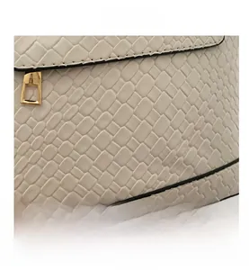Detailed macro view of white woven texture and golden zipper on crossbody bag
