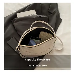 Internal view showing capacity of the white woven shell bag with phone and wallet