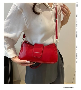 Close-up of bright red patent leather baguette bag with silver hardware and shoulder strap