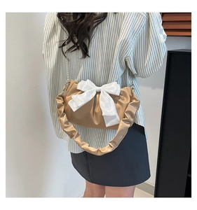 Vue arrière d'un sac à bandoulière beige plissé avec nœud en satin blanc et chaîne dorée