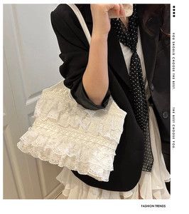 Close-up of white multi-layer lace ruffles and fine fabric texture on a tote bag