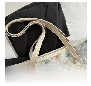 Detail of reinforced cream faux leather handles and 3D floral embroidery tote bag