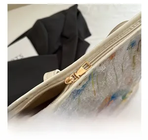 Detail of premium gold metal zipper and floral embroidery on textured tote bag