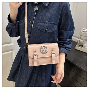 Sac bandoulière rose avec boucle métallique M argentée et sangles décoratives sur jean