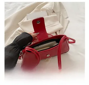 Internal view of a red patent leather shoulder bag showing capacity for daily essentials