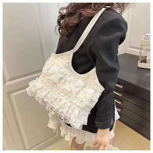 Detailed view of white lace ruffles and floral crochet pattern on a summer tote bag
