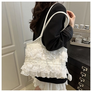Detail of multi-layer white lace ruffles and slim leather strap on a sweet tote bag