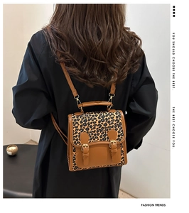 Detalle de mochila retro con estampado de leopardo, doble hebilla y correas de cuero PU