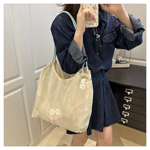 Détail de la broderie florale sur le sac cabas en mesh avec bandoulière à carreaux