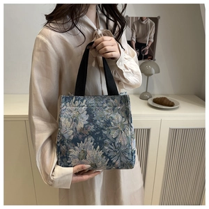 Close-up of vintage floral jacquard tote bag with blue-grey flower patterns and black strap