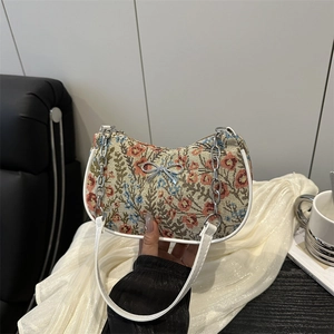 Sac à main en toile à fleurs avec garniture en cuir blanc et détail papillon argenté