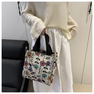 Detail of floral tote bag with black canvas handles and vintage botanical pattern