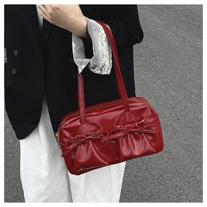 Detail der roten Lackleder-Handtasche mit Schleifentaschen und stilvoller Faltenstruktur