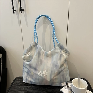 Blue tie-dye canvas tote bag with floral embroidery and woven straps for summer travel