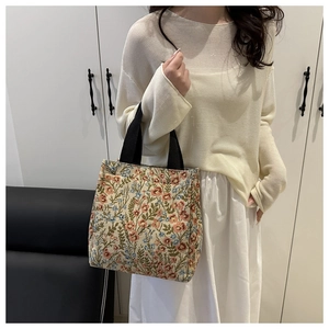 Floral tapestry shoulder bag featuring vintage embroidery and a wide black strap detail