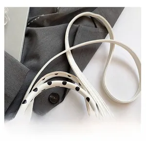 Close-up of white polka dot handbag showing durable shoulder strap and silver metal hooks