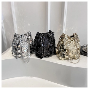 Dettaglio di borse a secchiello con paillettes scintillanti in argento, nero e oro con catena