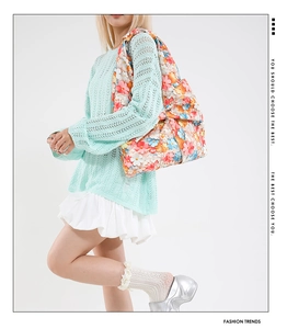 Detalle de bolso tote de lona floral con lazo grande decorativo llevado por una modelo