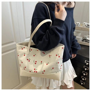 Detail of corduroy tote bag with red cherry print and reinforced leather base