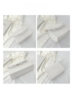 Detail view of white lace crossbody bag with pearl chain and 3D butterfly ornament