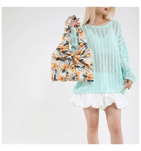 Detalle de bolso con estampado floral, lazo decorativo y textura de tela ligera