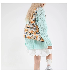 Primer plano del bolso bandolera acolchado con motivos florales amarillos y azules