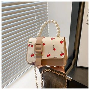 Détail du mini sac blanc à motif cerise avec anse perlée et bordure patchwork kaki