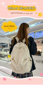 Detail of beige corduroy backpack showing side drawstring pocket and texture