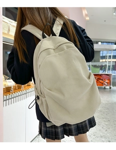 Detail of cream corduroy backpack with vertical texture and black drawstring closures